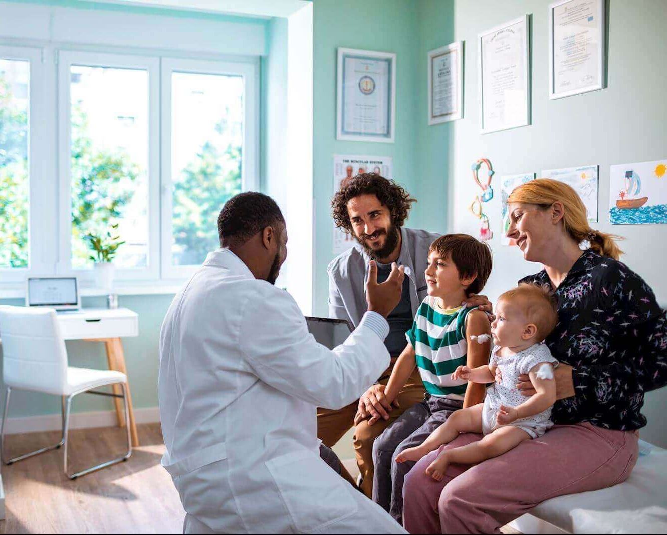 doctor provides a checkup on small child while family watches