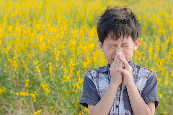 child blowing nose in field