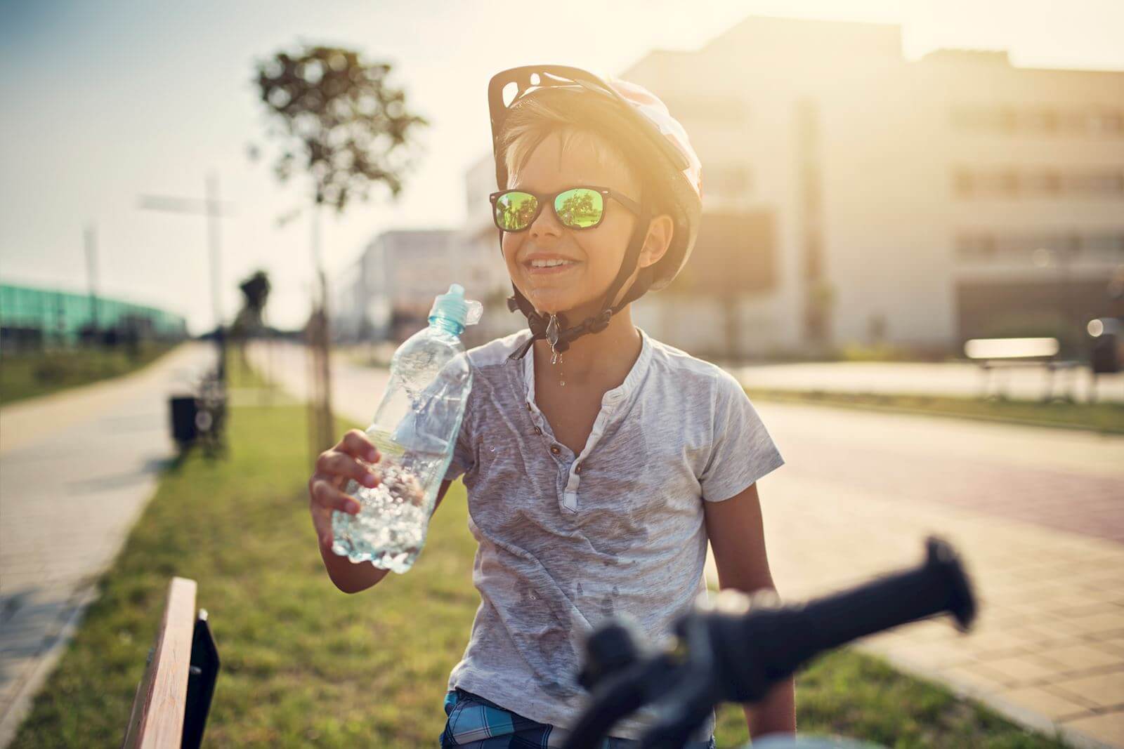 boy riding bike with water bottle