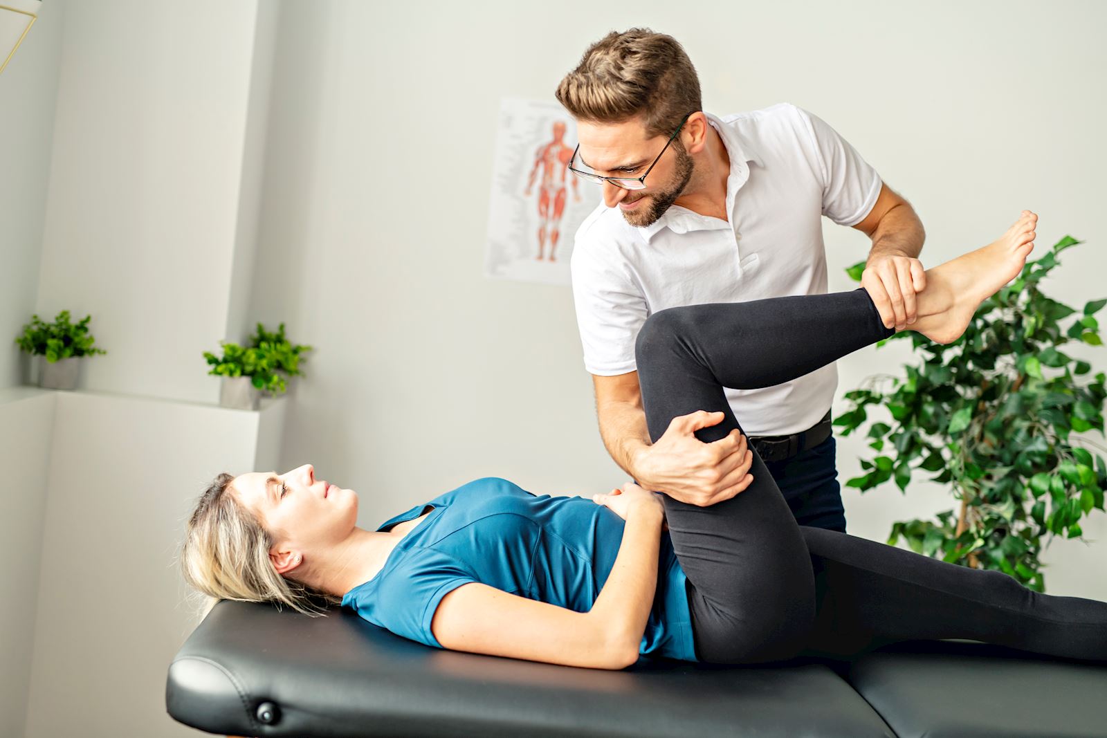 woman lies down during checkup with physical therapist