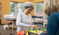 woman working with therapist on hand exercises