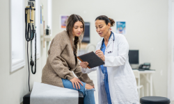 woman sitting with provider in exam room