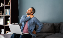 man in pain holding shoulder